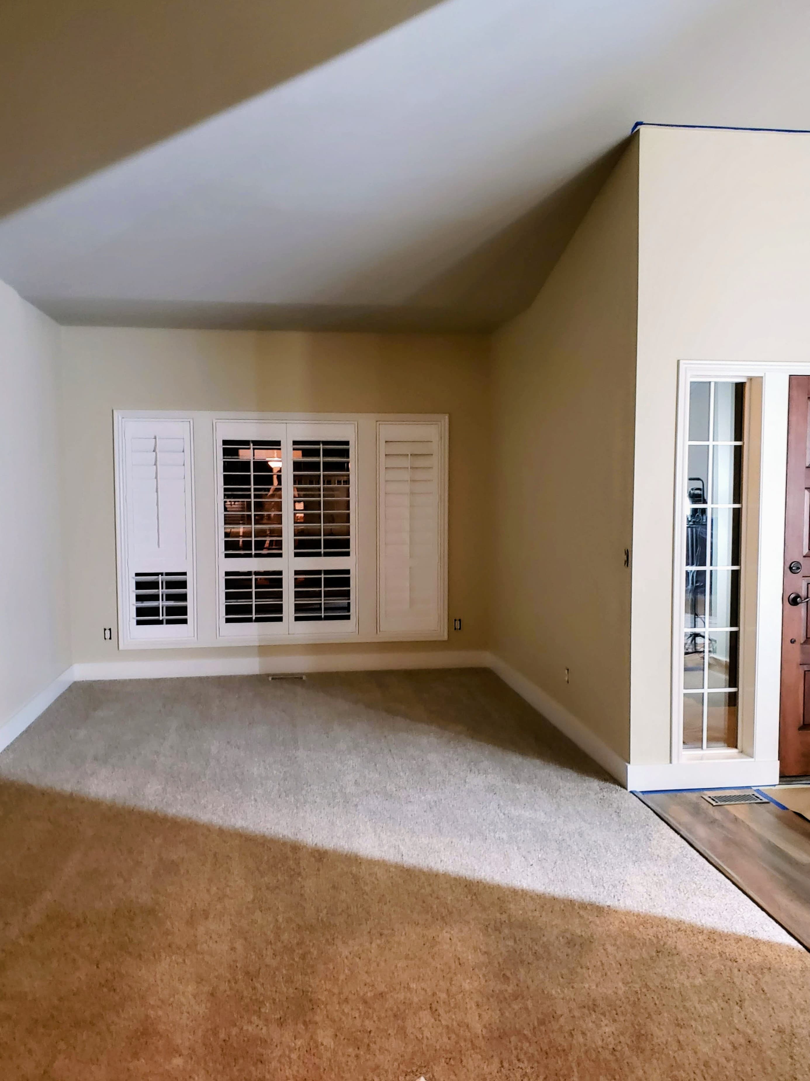 Finished bedroom with cream walls, white trim, and plantation shutters
