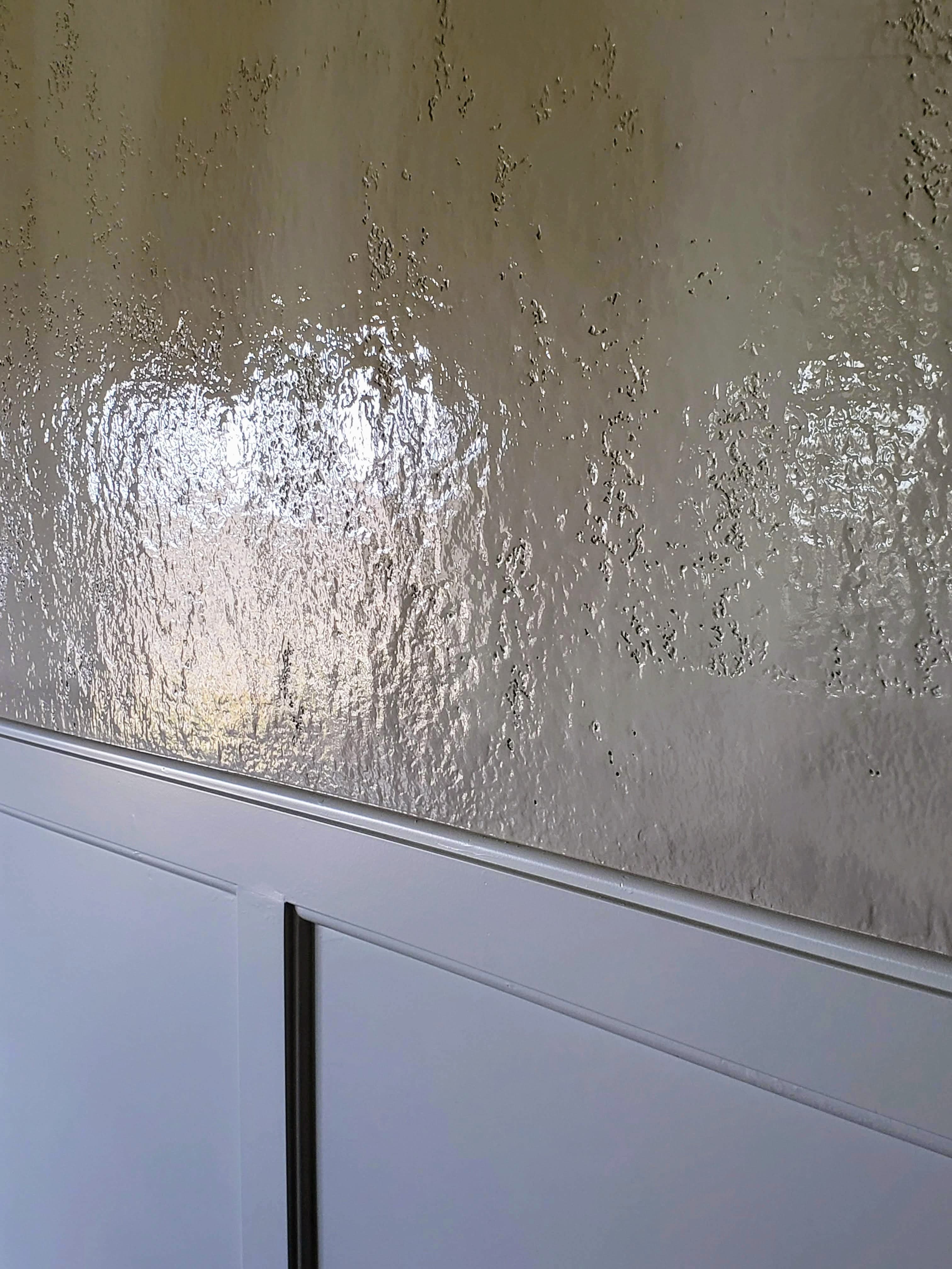 Smooth wainscoting and a textured painted wall