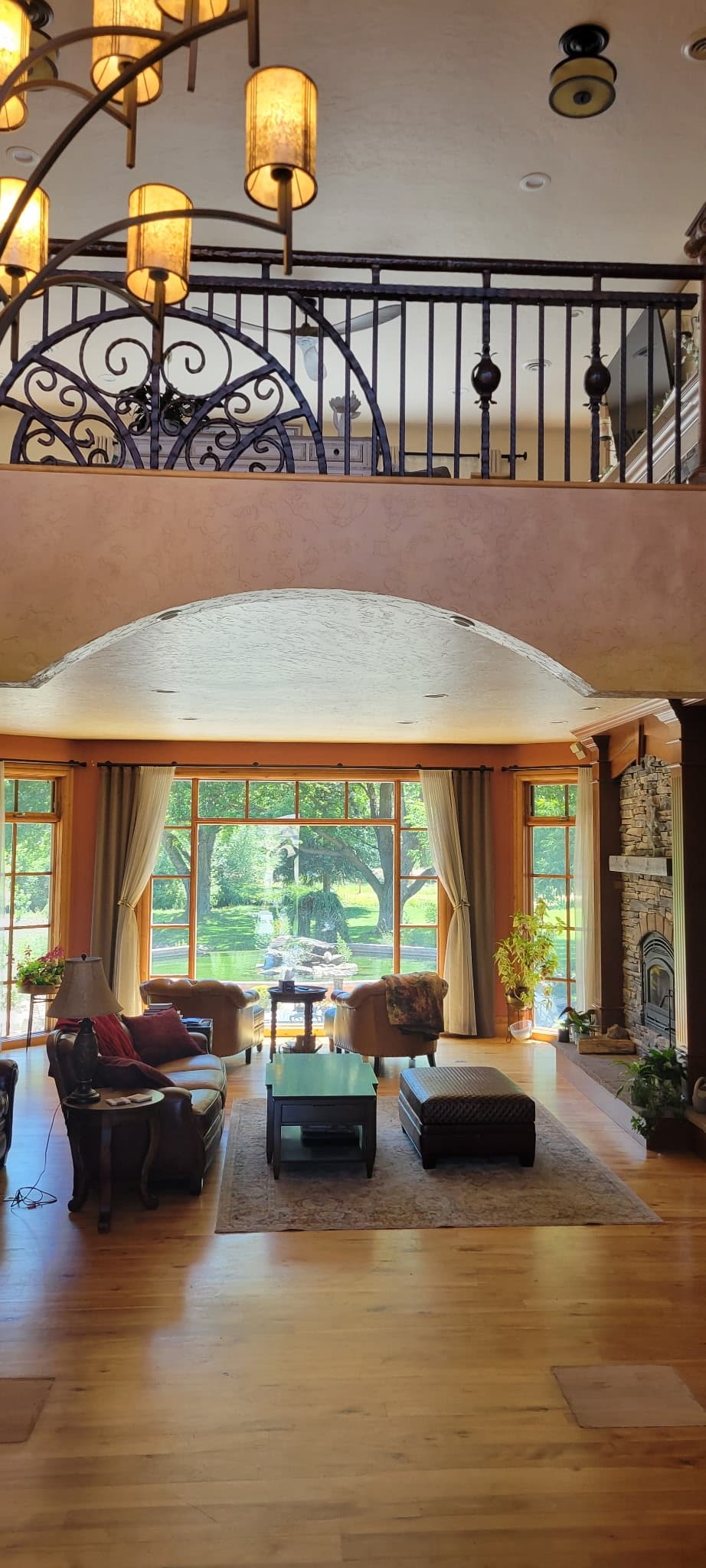 Two-story living room with painted walls, trim, and an arched opening